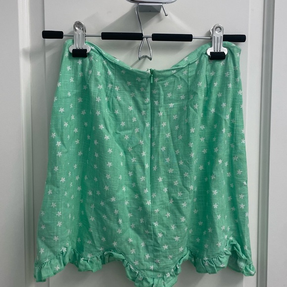 Green mini skirt with white flowers on them - Picture 2 of 2